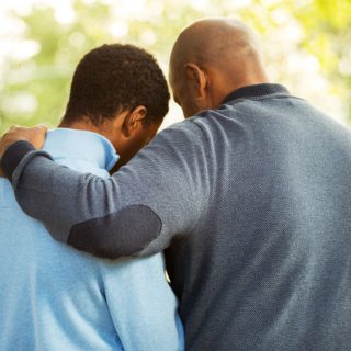 Father and Son Photo representing huddling to have a tough conversation