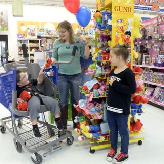 child with a physical disability shopping with his family