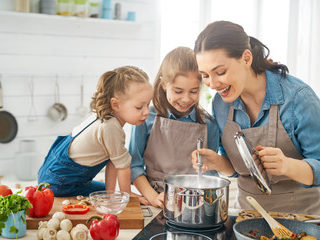 mother and daughters making dinner