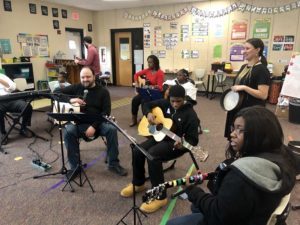 a diverse group of families and students playing instruments together