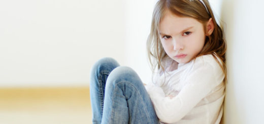 Young girl sitting with arms crossed and mad face while wearing rabbit ears