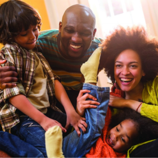 Family: dad, mom, young girl, and young boy playing together