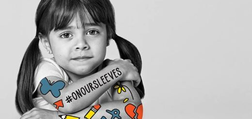 Black and white photo of young girl with #ONOURSLEEVES on her arm