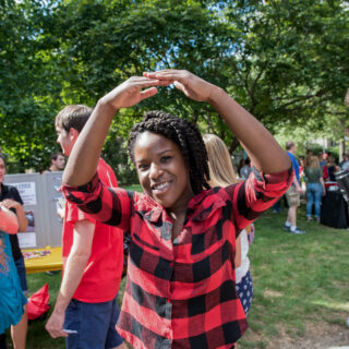 College student outside creating 'O' from Ohio with her arms