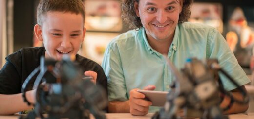 Father and son each playing with a small robot