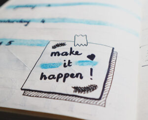 Doodle on paper that says make it happen!