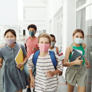 diverse looking group of middle school children wearing face masks at school