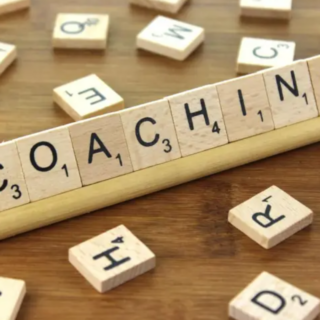 scrabble game letters spelling out the word "coaching"