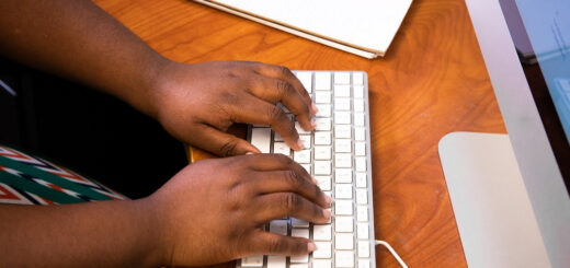 person typing a letter on a keyboard