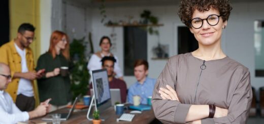 happy looking adult woman with people meeting at a table in the background